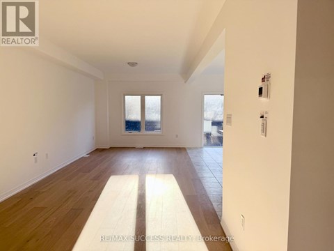 A spacious room with wooden floors and white walls.