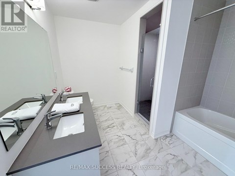 A bathroom with a marble floor and a large mirror above the sink.