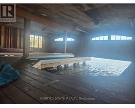 A room with a pool in the middle and a sign that says "NORTH 2 SOUTH REALTY, Brokerage".
