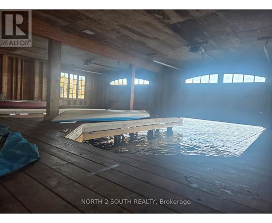 A room with a pool in the middle and a sign that says "NORTH 2 SOUTH REALTY, Brokerage".