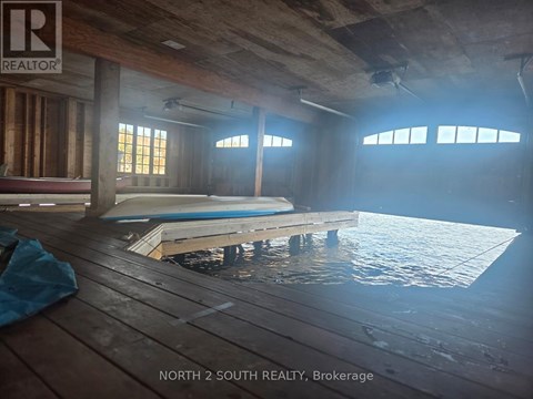 A room with a pool in the middle and a sign that says "NORTH 2 SOUTH REALTY, Brokerage".