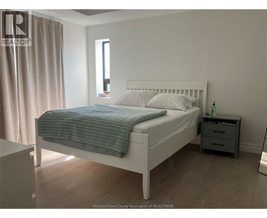 A bedroom with a white bed and a blue blanket.