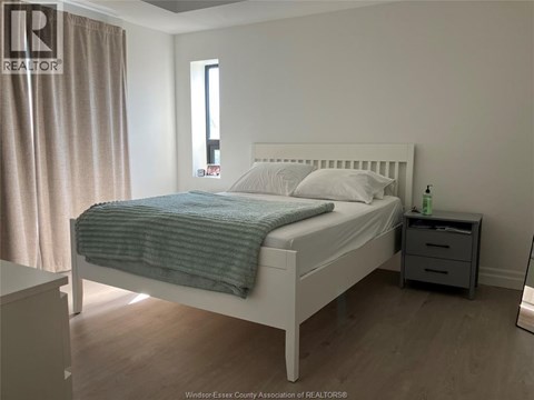 A bedroom with a white bed and a blue blanket.