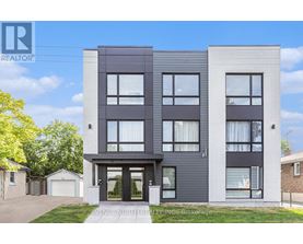 A modern two-story building with a realtor logo on the top left corner.