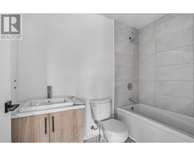 A bathroom with a toilet, sink, and bathtub.