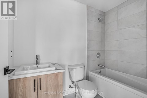 A bathroom with a toilet, sink, and bathtub.