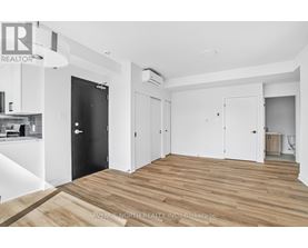A spacious room with wooden flooring and white walls.