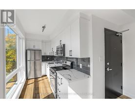 A modern kitchen with stainless steel appliances and white cabinets.