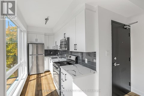 A modern kitchen with stainless steel appliances and white cabinets.