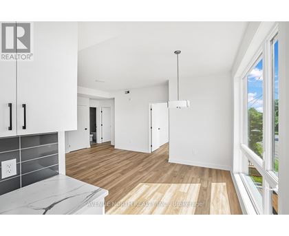 A real estate company's logo is displayed on a wall in a modern, empty living space.