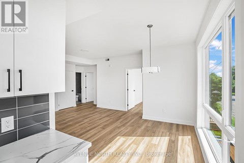 A real estate company's logo is displayed on a wall in a modern, empty living space.