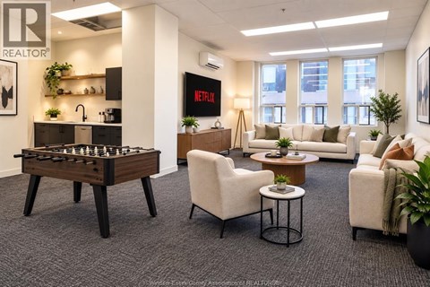 A living room with a foosball table and a couch.