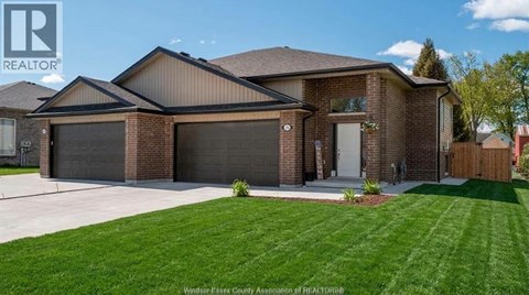 A house with a brown brick exterior and a large front yard.