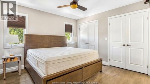 A bedroom with a large bed and a ceiling fan.
