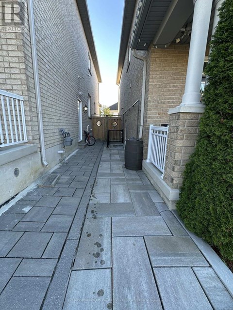 A concrete walkway leads to a gate with a metal railing on either side.