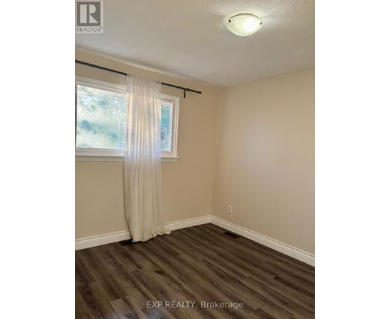 A room with a window and a curtain.