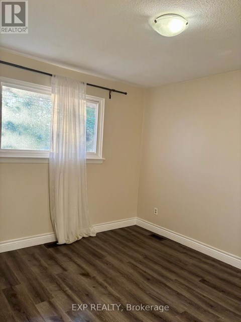 A room with a window and a curtain.