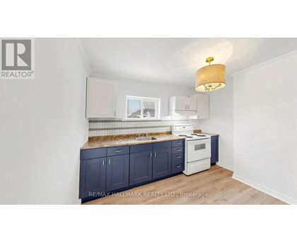 A kitchen with dark blue cabinets and a white oven.