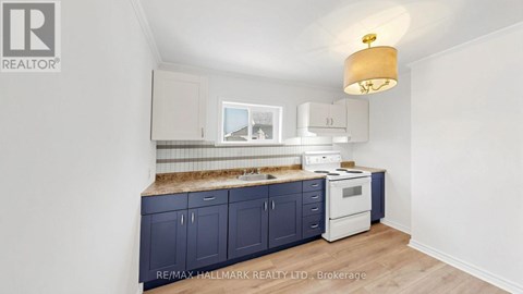 A kitchen with dark blue cabinets and a white oven.