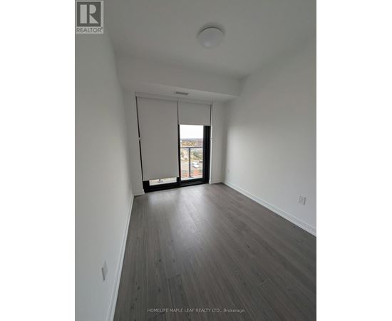 A room with a sliding glass door leading to a balcony.