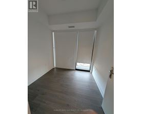 A room with wooden flooring and white walls.