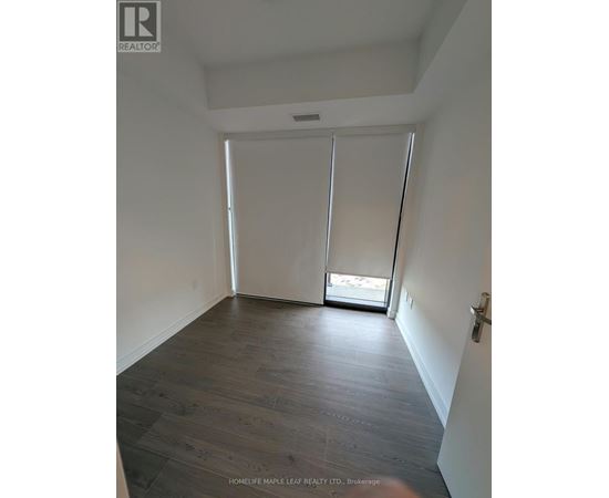 A room with wooden flooring and white walls.