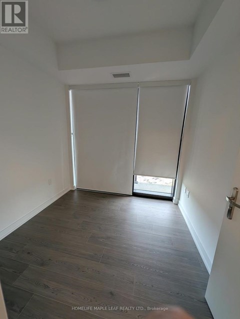 A room with wooden flooring and white walls.