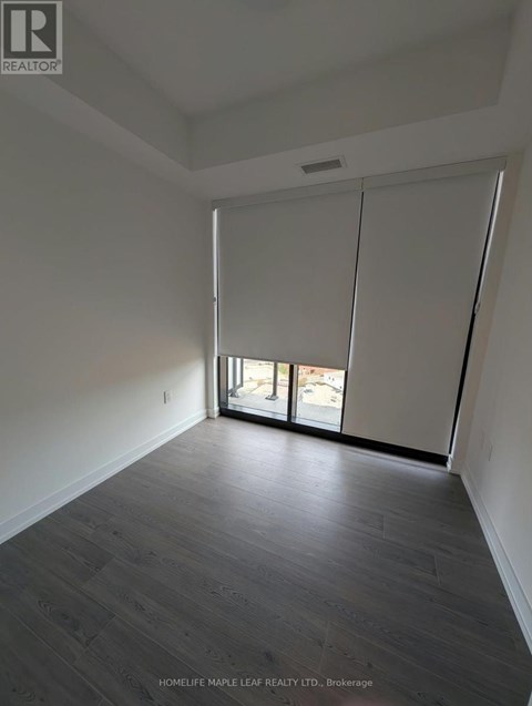A room with a sliding glass door leading to a balcony.