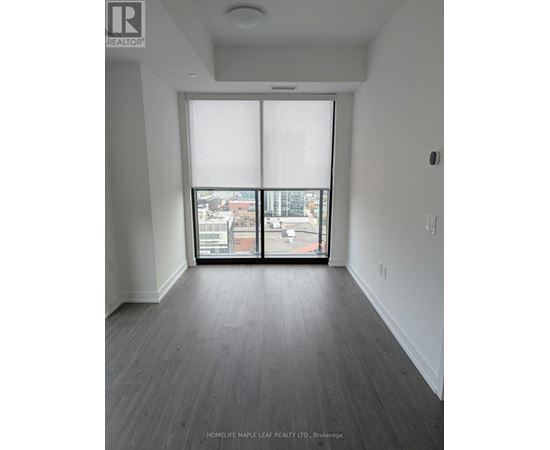 A room with a view of the city through large windows.