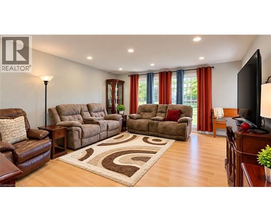 A living room with brown furniture and a rug.