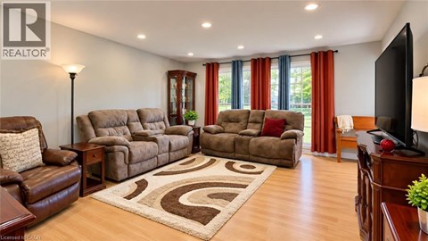 A living room with brown furniture and a rug.