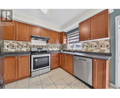 A kitchen with brown cabinets and a tiled backsplash.