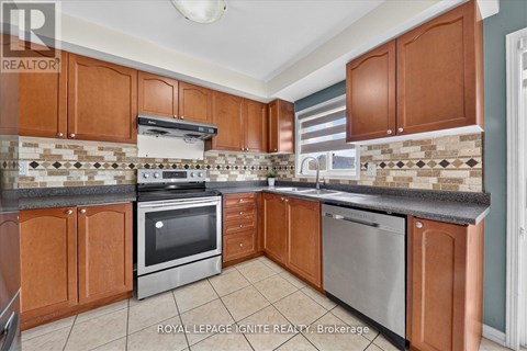 A kitchen with brown cabinets and a tiled backsplash.