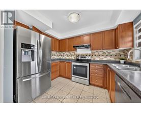A kitchen with a stainless steel refrigerator and wooden cabinets.