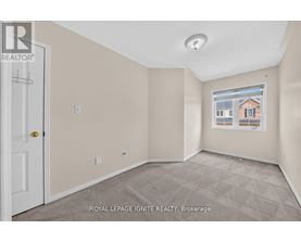 A room with a door and a window showing a building outside.