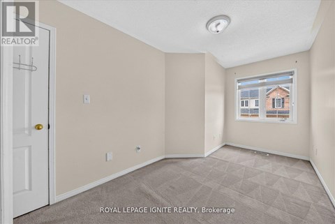 A room with a door and a window showing a building outside.