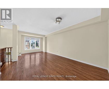 A spacious room with wooden flooring and a ceiling light fixture.