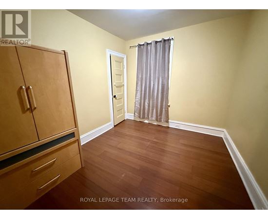 A room with a wooden floor and a brown cabinet.