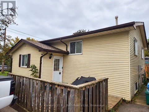 A beige house with a white door and a small window.
