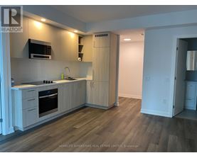 A white door is open to a small laundry room with two washing machines.