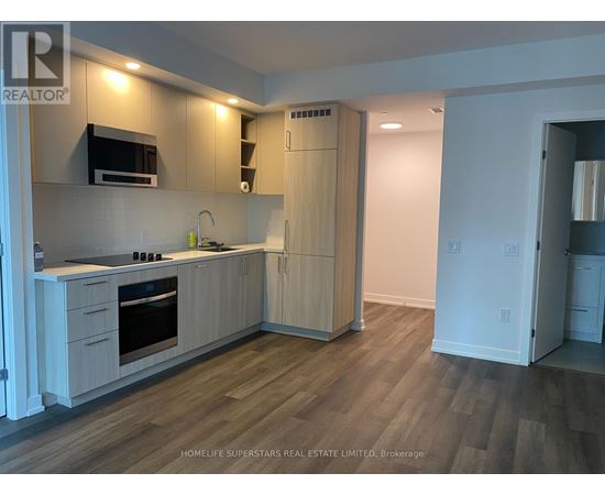 A white door is open to a small laundry room with two washing machines.