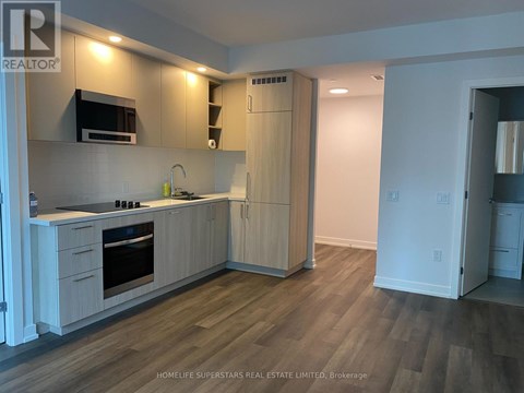A white door is open to a small laundry room with two washing machines.