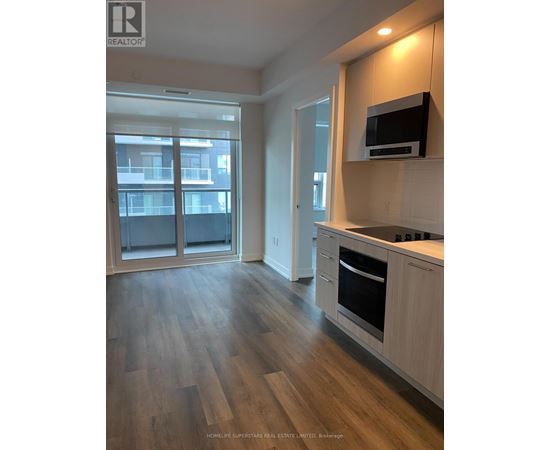 A kitchen with wooden floors and a microwave on the counter.