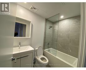 A bathroom with a toilet, sink, and shower.
