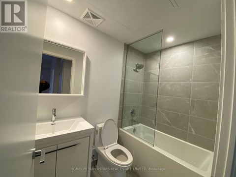 A bathroom with a toilet, sink, and shower.