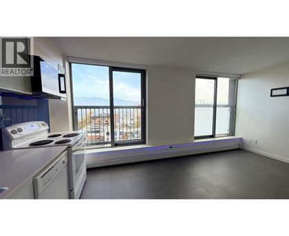 A kitchen with a stove top oven and a window overlooking a balcony.