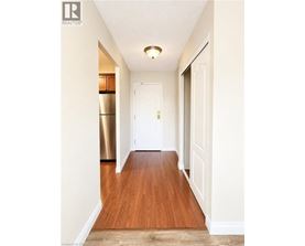 A hallway with a white door and a wooden floor.