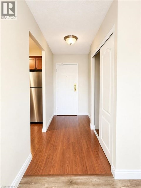 A hallway with a white door and a wooden floor.