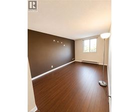 A room with wooden flooring and a window.
