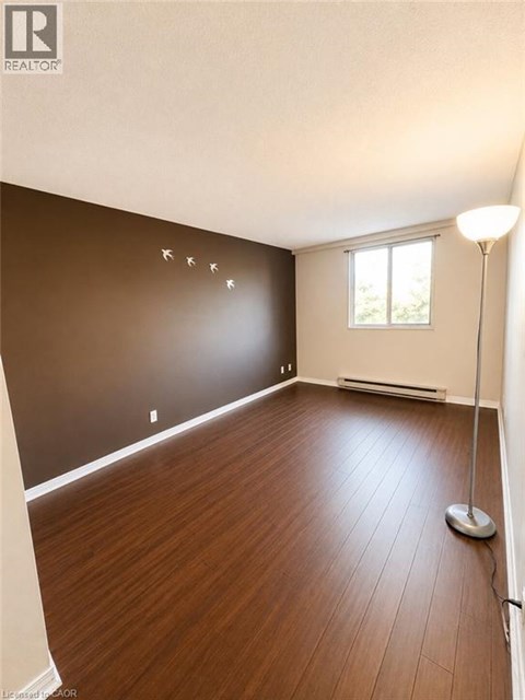 A room with wooden flooring and a window.